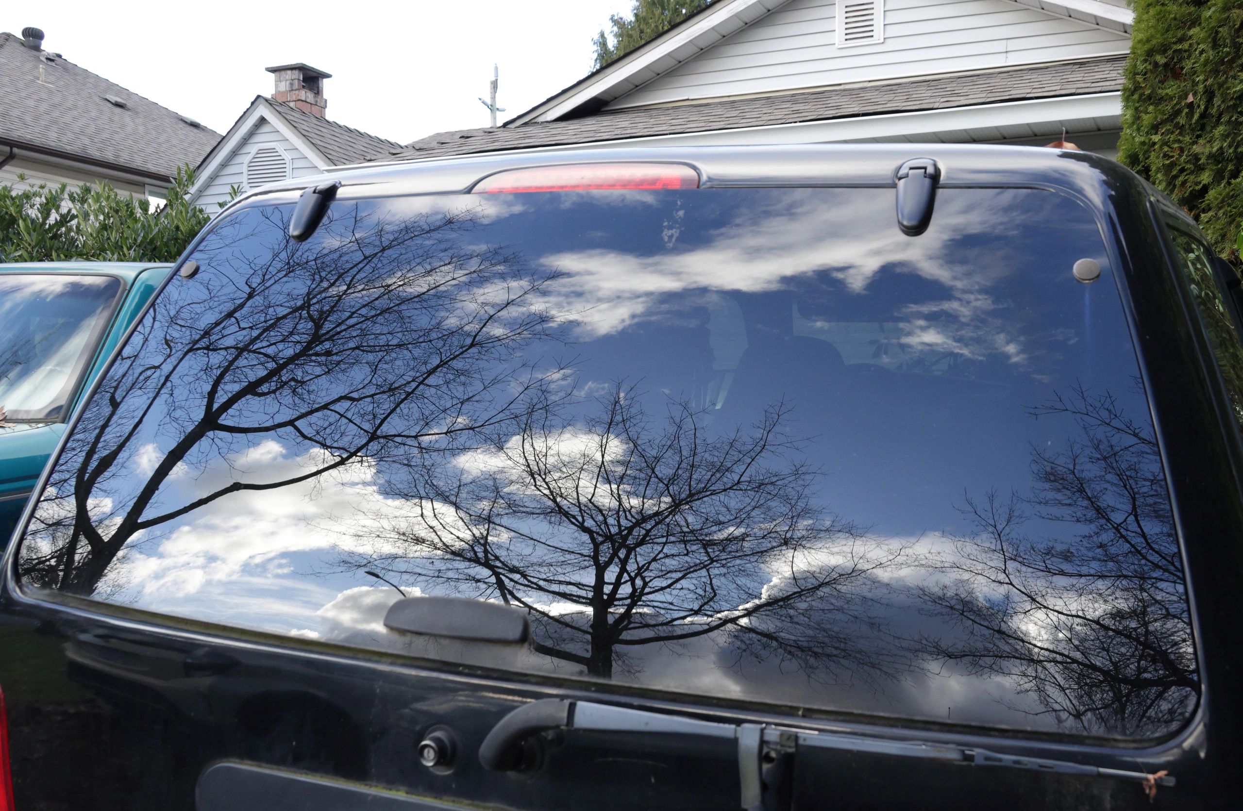 Dark vehicle window with reflective polished surface